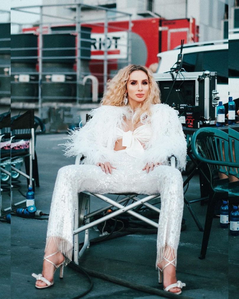 Светлана Лобода сидит в стильном белом костюме